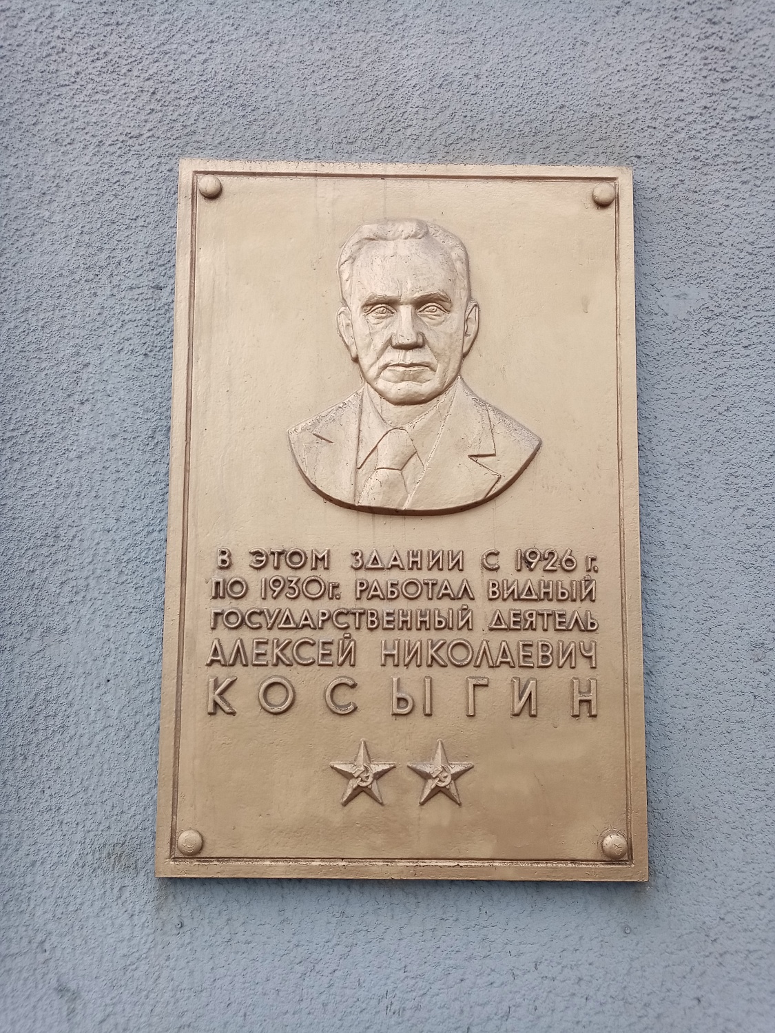 Мемориальная доска Алексея Николаевича Косыгина с годами его работы в здании Облпотребсоюза.